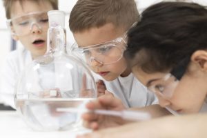 ninos-curiosos-haciendo-un-experimento-quimico-en-la-escuela